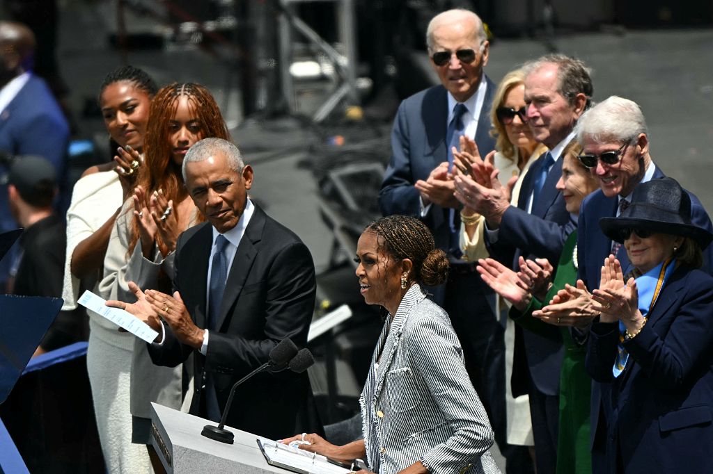 Au Centre Obama, Barack et Michelle délivrent un message d'espoir et critiques subtiles de Trump.